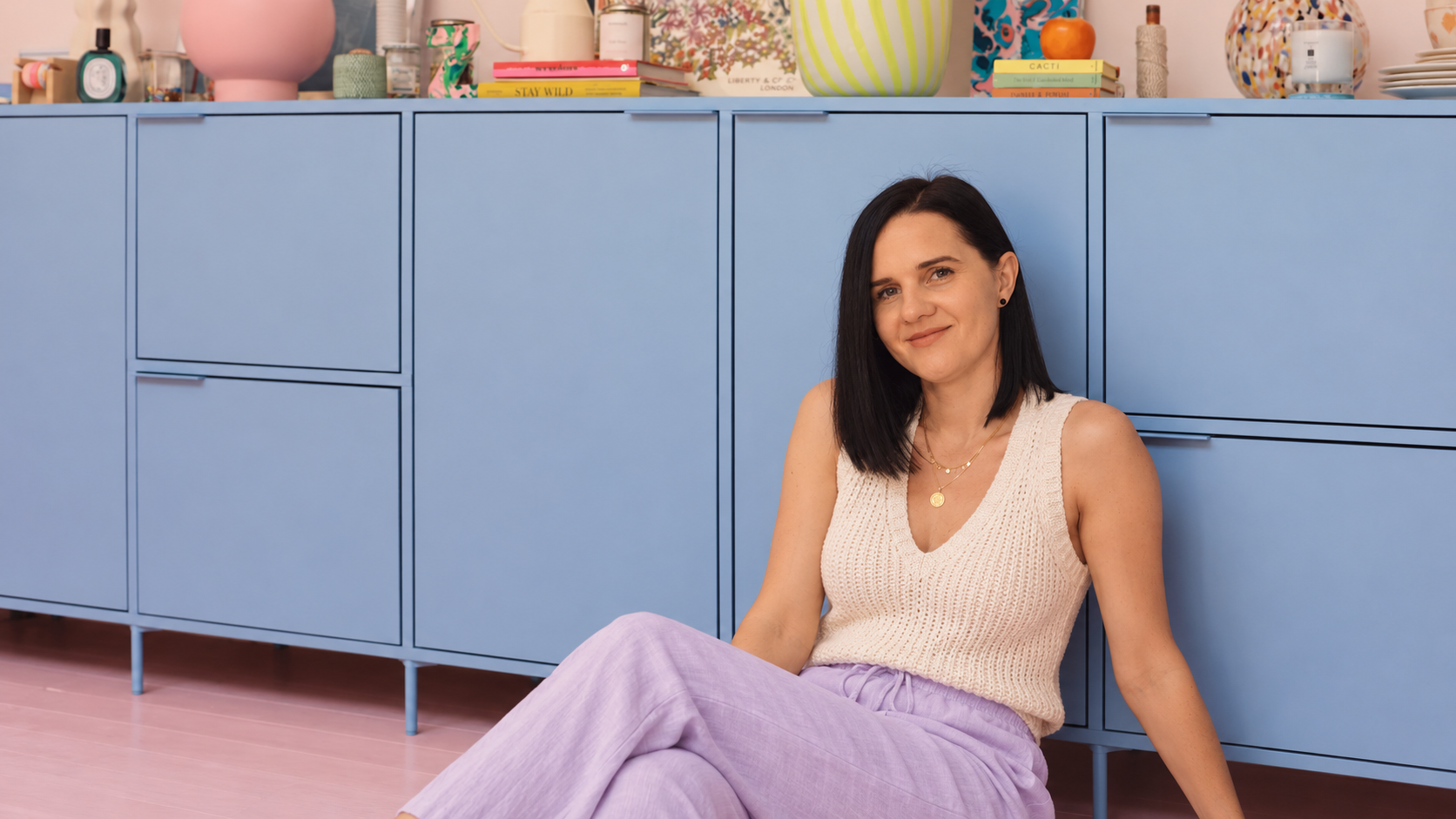 Kasia Ogonowska sitting in front of blue cabinets